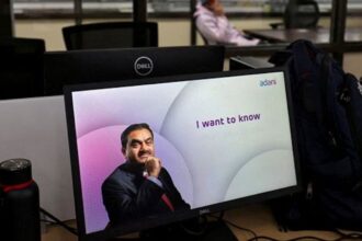 A technician talks on his cell phone at the Photovoltaic Modules assembling plant of Adani Green Energy Ltd, in Mundra. (Reuters File)