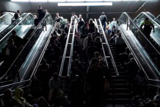 People rest on the stairs at Atocha train station during a power outage