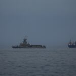 A UAE navy vessel patrols next to cargo ships and oil tankers in the Strait of Hormuz as seen from Khor Fakkan, United Arab Emirates.