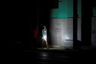 People walk on a street during a blackout in Havana, Cuba, Saturday, March 21, 2026. (AP Photo/Ramon Espinosa)