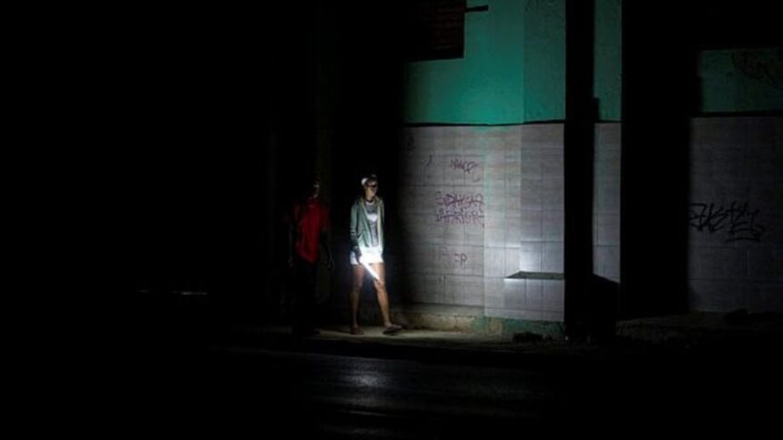 People walk on a street during a blackout in Havana, Cuba, Saturday, March 21, 2026. (AP Photo/Ramon Espinosa)