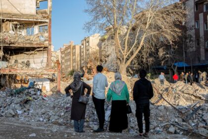 People walk through an area hit by airstrikes in Tehran, Iran