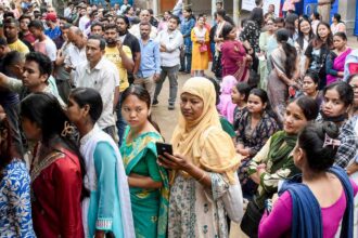 People wait in queues before casting their votes in the Assam Assembly elections, at a polling station in Guwahati. (PTI Photo) Assam