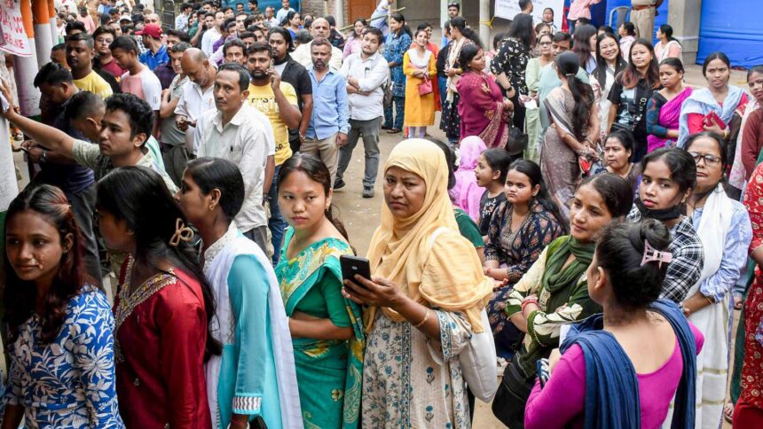 People wait in queues before casting their votes in the Assam Assembly elections, at a polling station in Guwahati. (PTI Photo) Assam