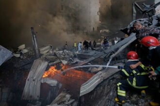 Firefighters try to put out flames at the site of an Israeli airstrike that struck an apartment building in Beirut, Lebanon, Wednesday. (AP Photo)