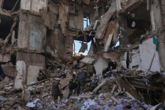 Lebanese civil defense workers search for victims in the rubble of a building destroyed in an Israeli airstrike a day earlier in central Beirut, Lebanon. (AP Photo)