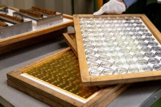 Trays of silver coins and gold bars at the Polish mint, also known as Mennica Polska SA, in Warsaw, Poland, on Thursday, Feb. 12, 2026. Polands central bank, the worlds biggest reported buyer of gold, is boosting purchases by another 150 tons as it braces for more of the geopolitical instability that has driven prices to record highs. Photographer: Damian Lemanski/Bloomberg