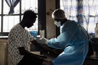 A patient prepares to have blood drawn for a test at General Referral Hospital of Mongbwalu during the Ebola outbreak response in Mongbwalu, Ituri province, Democratic Republic of Congo on May 20. | Michel Lunanga/Getty Images