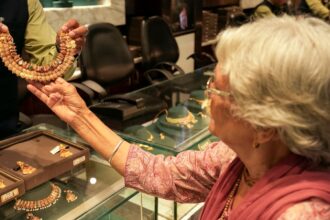 A customer checks a necklace at a jewellery shop