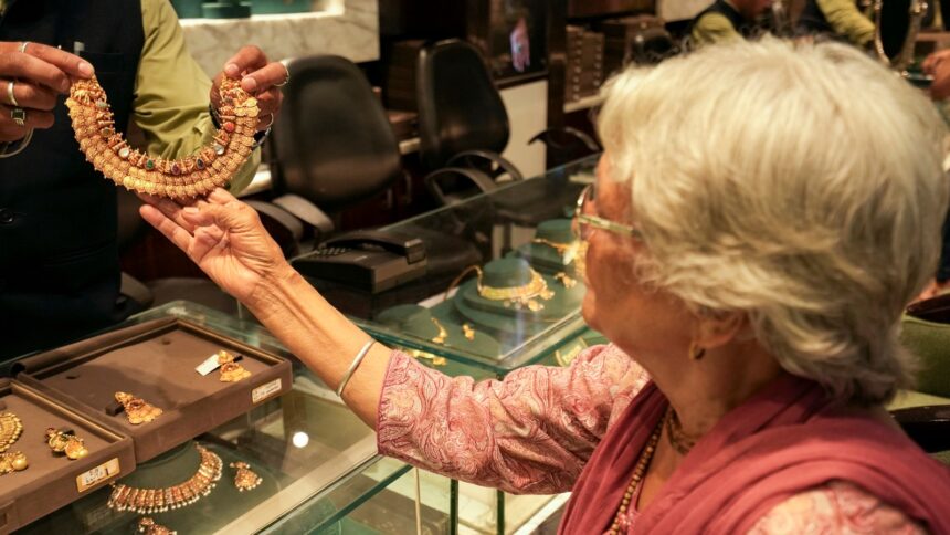A customer checks a necklace at a jewellery shop