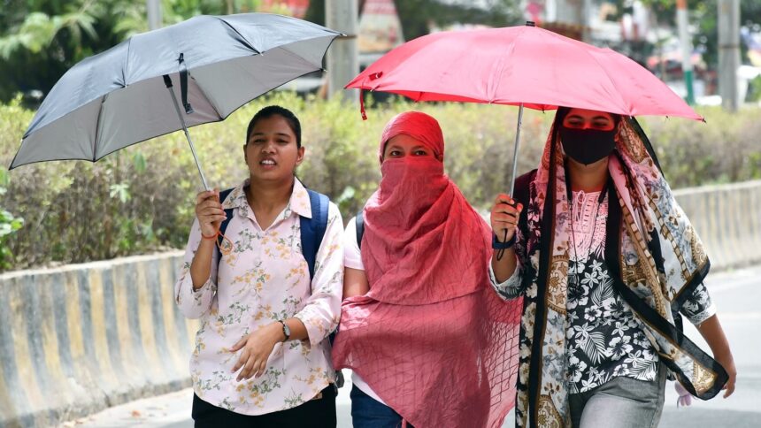 Women cover their faces with scarves and shield themselves from the heat with umbrellas on a hot summer day