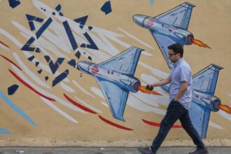 A man walks past an anti-Israel mural in downtown Tehran, Iran, Sunday, May 17, 2026. (AP Photo/Vahid Salemi)