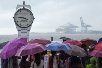 Visitors at the Marine Drive on a rainy afternoon, in Kochi. (PTI Photo)