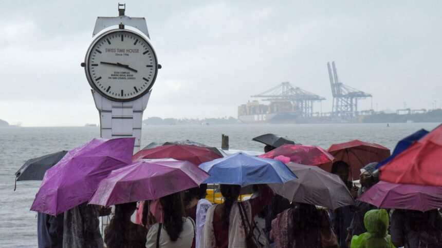 Visitors at the Marine Drive on a rainy afternoon, in Kochi. (PTI Photo)