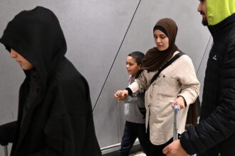 A group of supporters surround a woman and child with alleged ties to the Islamic State as they arrive at Melbourne international Airport, in Melbourne, Australia (Photo/AP)