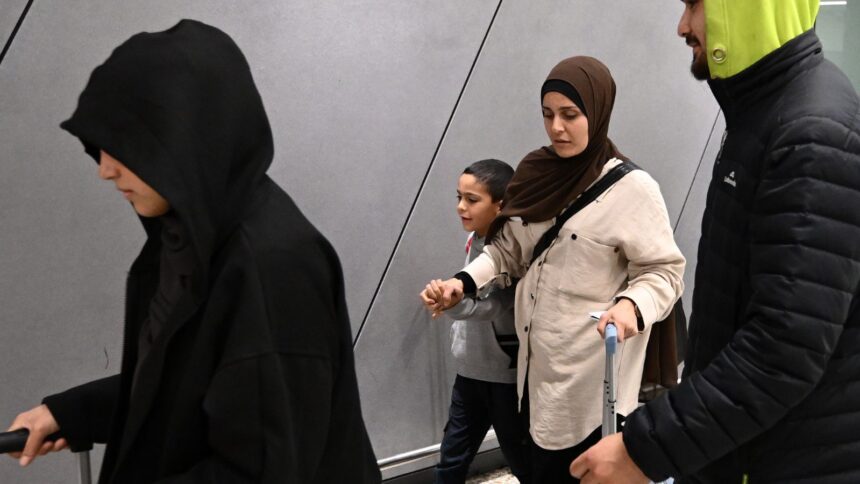 A group of supporters surround a woman and child with alleged ties to the Islamic State as they arrive at Melbourne international Airport, in Melbourne, Australia (Photo/AP)