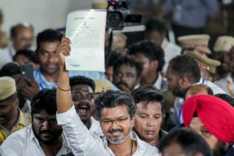 Tamilaga Vettri Kazhagam (TVK) chief and candidate from the Tiruchirappalli East constituency, Vijay, shows an election certificate outside a centre as he leads in vote counting for Tamil Nadu Assembly elections, in Chennai, Monday, May 4, 2026.