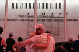 A couple kiss in front of the John F. Kennedy Center for the Performing Arts, Friday, June 12, 2026, in Washington. (AP Photo)