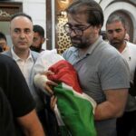 Fahd Abu Haikal, 41 carries the body of his seven month old Palestinian baby boy Sam, who was killed on Friday when, according to the Palestinian health ministry, Israeli soldiers fired at the vehicle carrying him and his parents in Tel Rumeida, during his funeral in the West Bank city of Hebron, Saturday, June 6, 2026. (AP Photo/Mahmoud Illean)