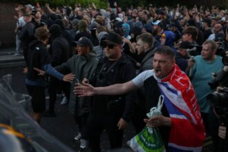 Protesters stand facing police officers during a demonstration following the conviction of Vikrum Digwa for the murder of student Henry Nowak, in Southampton, on June 2, 2026. (REUTERS)