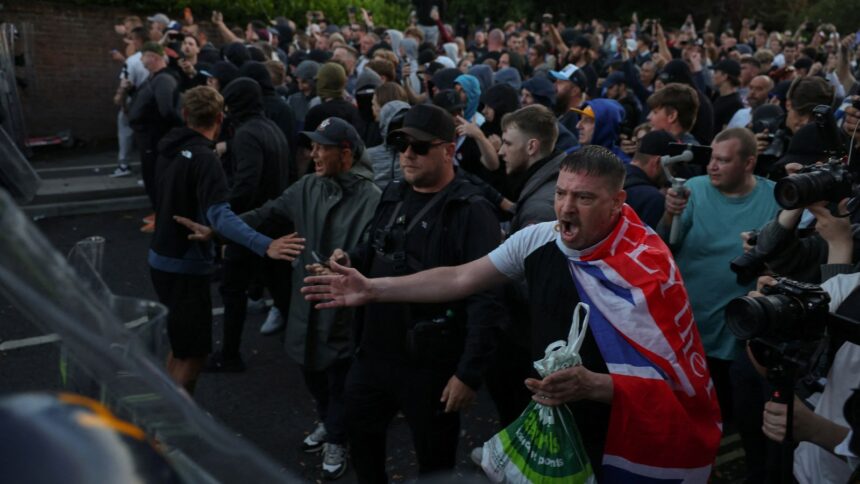 Protesters stand facing police officers during a demonstration following the conviction of Vikrum Digwa for the murder of student Henry Nowak, in Southampton, on June 2, 2026. (REUTERS)