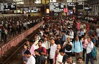 Commuters wait on the platform to board a local train at CSMT railway station
