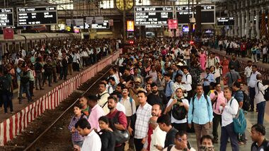 Commuters wait on the platform to board a local train at CSMT railway station