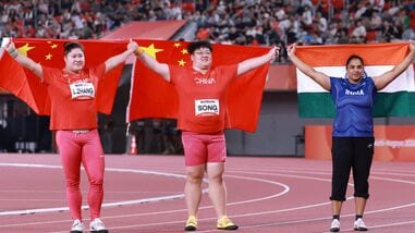 Gold medalist China's Song Jiayuan (C), silver medalist China's Zhang Linru (L) and bronze medalist India's Manpreet Kaur celebrate after the women's shot put final during the 2026 Asian Games in Nagoya on Friday.