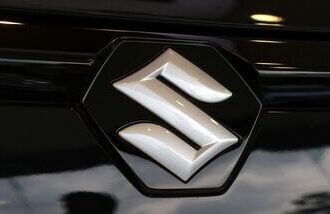 The logo of Maruti Suzuki on a e Vitara SUV car parked inside a showroom in Ahmedabad, India.