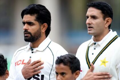 Pakistan's Babar Azam (L) and Mohammad Abbas line up during the national anthems before the match.