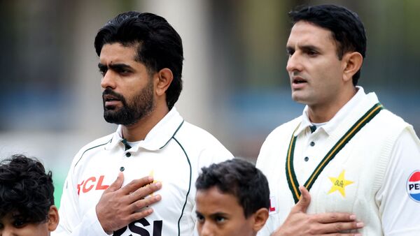 Pakistan's Babar Azam (L) and Mohammad Abbas line up during the national anthems before the match.