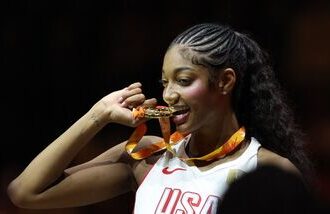 Angel Reese of the US celebrates with her gold medal after winning the FIBA Women's World Cup Final