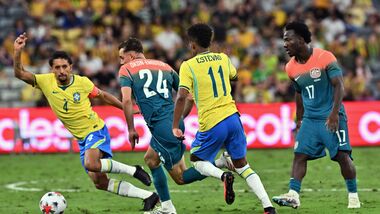 Brazil's Marquinhos (L) and Australia's Paul Okon-Engstler (2nd-L) compete for the ball as Australia's Nestory Irankunda watches during the International friendly football match between Australia and Brazil at Queensland Country Bank Stadium in Townsville on September 25, 2026.