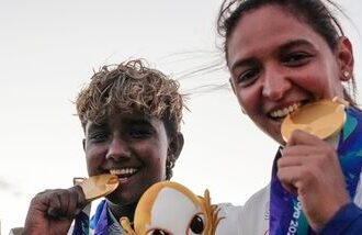 India's captain Harmanpreet Kaur (R) and G Kamalini pose with gold medals after winning the women's cricket final at Asian Games 2026.