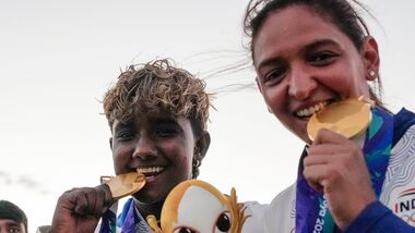 India's captain Harmanpreet Kaur (R) and G Kamalini pose with gold medals after winning the women's cricket final at Asian Games 2026.