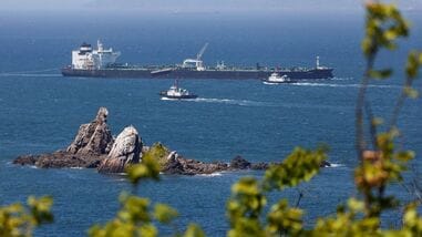 Tugboats guide a crude-oil tanker after passing through the Strait of Hormuz.