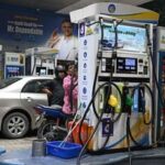 Petrol pump attendants refuel vehicles at a Bharat Petroleum (BP) gas station in New Delhi