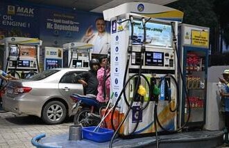 Petrol pump attendants refuel vehicles at a Bharat Petroleum (BP) gas station in New Delhi