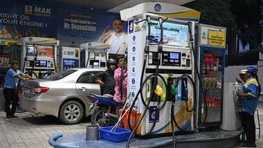 Petrol pump attendants refuel vehicles at a Bharat Petroleum (BP) gas station in New Delhi