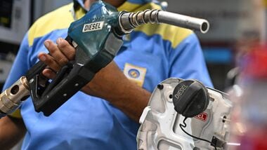 A petrol pump attendant refuels a vehicle at a Bharat Petroleum (BP) gas station in New Delhi