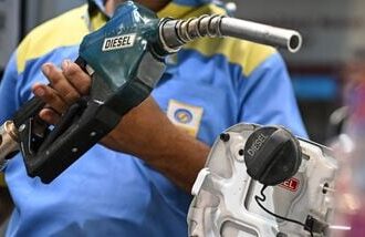 A petrol pump attendant refuels a vehicle at a Bharat Petroleum (BP) gas station in New Delhi