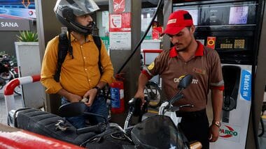 A man watches the litres and rupee amount displayed at the pump as he refuels his vehicle at a petrol station, as fuel prices rise amid the US-Iran conflict