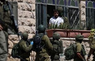 Israeli soldiers talk to a Palestinian man, as they conduct raid in Anata, in the Israeli-occupied West Bank, September 8, 2026. REUTERS/Ammar Awad