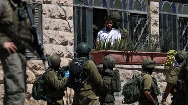 Israeli soldiers talk to a Palestinian man, as they conduct raid in Anata, in the Israeli-occupied West Bank, September 8, 2026. REUTERS/Ammar Awad