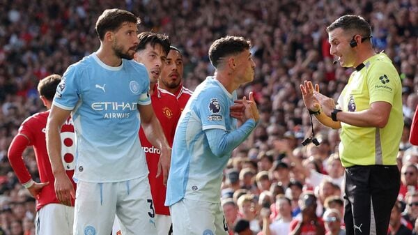 Manchester City's Phil Foden remonstrates with referee Michael Oliver after being shown a red card against Manchester United.