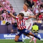 Real Madrid's Dean Huijsen, right, fouls Atletico Madrid's Giuliano Simeone to see a red card during a Spanish La Liga soccer match.