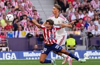 Real Madrid's Dean Huijsen, right, fouls Atletico Madrid's Giuliano Simeone to see a red card during a Spanish La Liga soccer match.