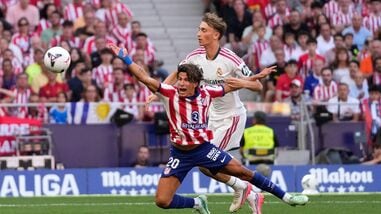 Real Madrid's Dean Huijsen, right, fouls Atletico Madrid's Giuliano Simeone to see a red card during a Spanish La Liga soccer match.