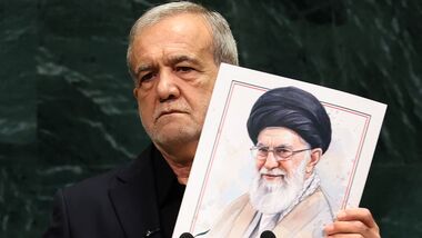 Iran's President Masoud Pezeshkian speaks as he holds a picture of Ali Khamenei, former Supreme Leader of Iran, during the 81st United Nations General Assembly at the United Nations Headquarters in New York, on September 23, 2026. (Photo by TIMOTHY A. CLARY / AFP)