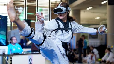 A virtual taekwondo competitor performs a high kick during a competitive event in Kuala Lumpur, Malaysia